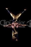 Smiling muscular acrobats isolated on black