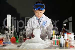 Adorable smart boy doing experiment in studio