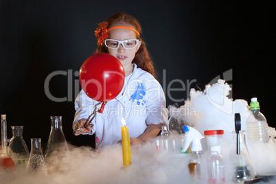 Image of cute little schoolgirl watching reagents