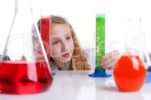 Lovely schoolgirl looking at flasks with chemicals