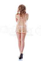Curly slim girl posing in beige erotic negligee