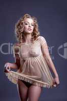 Coquettishly smiling girl posing in negligee