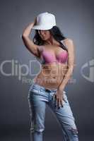 Portrait of sensual girl in cap, bra and jeans