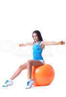 Confident girl exercising with dumbbells in studio