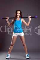 Studio shot of cute sporty girl posing with fitbar
