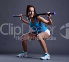 Smiling sporty woman crouches with fitbar