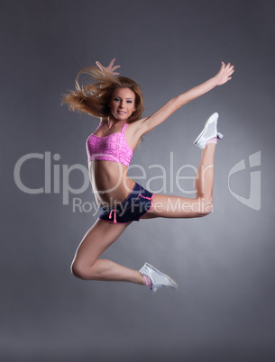 Studio shot of pretty sportswoman posing in jump