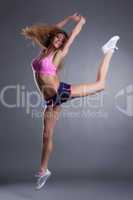 Graceful sportswoman jumping in studio