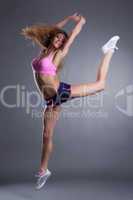 Graceful sportswoman jumping in studio