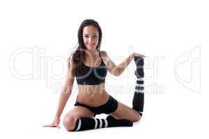 Pretty merry brunette doing stretching in studio
