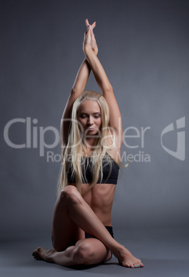 Image of becalmed blonde doing yoga in studio