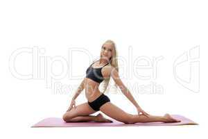 Pretty fitness instructor posing on gymnastic mat