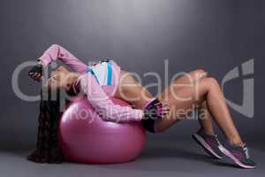 Sexual sporty woman posing with ball for fitness