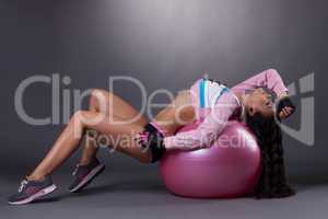 Passionate slim woman posing on fitness ball