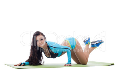 Curvy athletic brunette lying on gymnastic mat