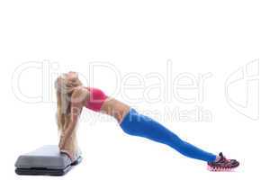Long-haired slim woman exercising on stepper