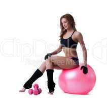 Smiling athletic woman sitting on fitness ball