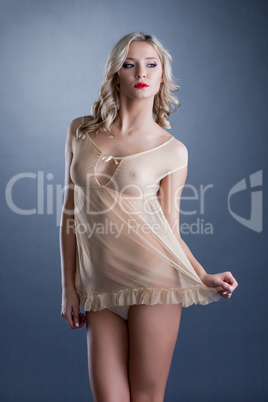 Attractive young woman in sexy beige negligee