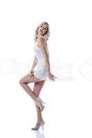 Flirtatious slim girl posing in white short dress