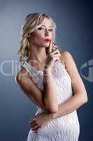 Studio shot of stylish young blonde in white dress