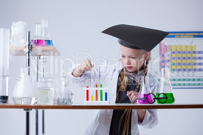 Image of smart little girl mixes reagents in lab