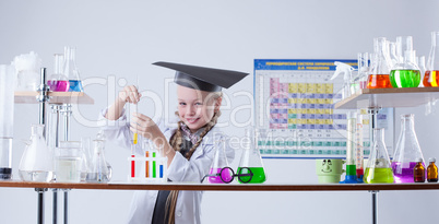 Adorable little chemist posing in lab with flasks