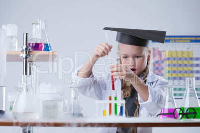 Surprised girl looking at test tubes with reagents