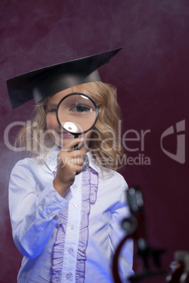 Curious girl looking through magnifying glass