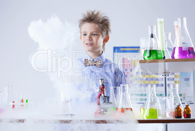 Curious pupil posing with test tubes and flasks