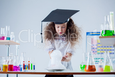 Curious girl watching result of experiment in lab