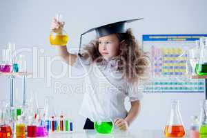 Cute girl posing with colorful test-tubes in lab