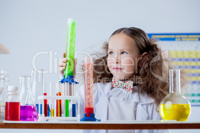 Image of cute girl posing with colorful flasks