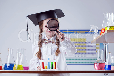 Portrait of pretty girl looking through magnifier