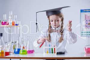 Image of smart girl mixing tubes in laboratory