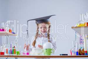 Curious schoolgirl conducting experiment in lab
