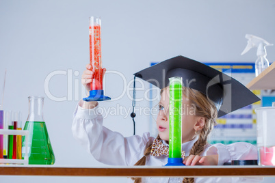 Interested schoolgirl considering colorful flasks