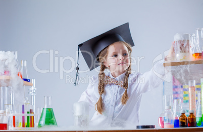 Adorable little girl conducting experiment in lab