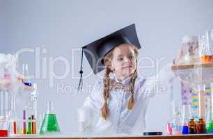 Adorable little girl conducting experiment in lab