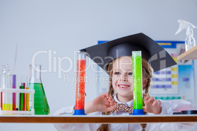 Smiling little chemist posing with colorful flasks