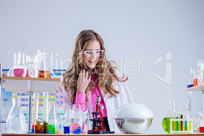 Surprised schoolgirl conducts chemical experiment