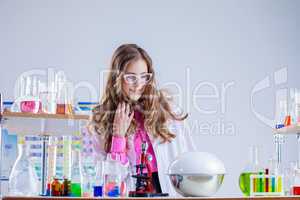 Surprised schoolgirl conducts chemical experiment