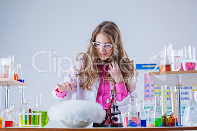 Cute student watching over experiment in lab