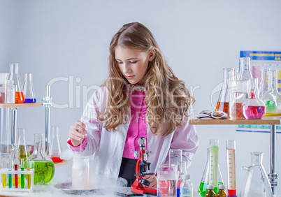 Image of young scientist stirs reagent in flask