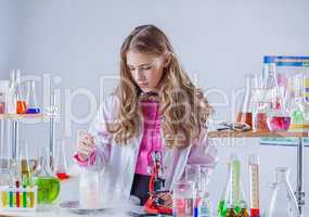 Image of young scientist stirs reagent in flask