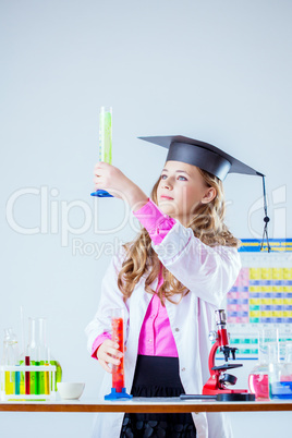 Pretty student looks at reagent in test tube