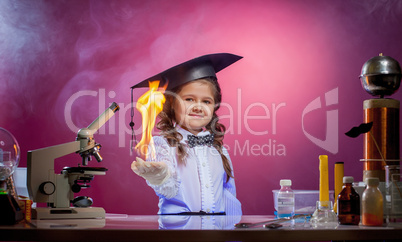 Cute little magician holding fire in palm of hand