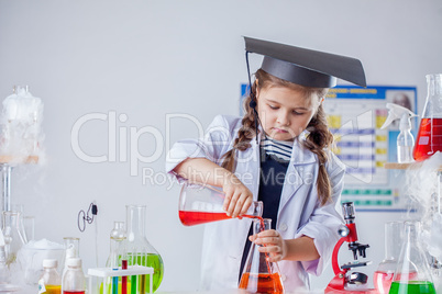 Image of cute chemist pours reagent into flask