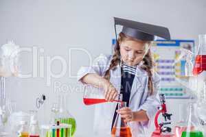 Image of cute chemist pours reagent into flask