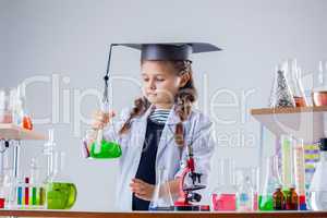 Concentrated little girl posing in chemistry lab