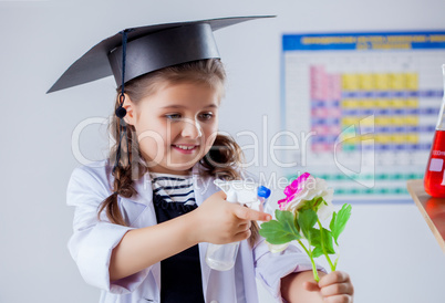 Smiling student biologist sprinkles flower